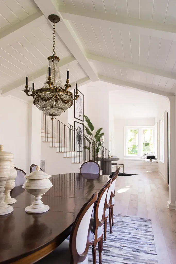Elegant dining room remodel with vaulted ceiling, vintage chandelier, and open layout connecting to entryway in Guana Estates home renovation. North Guana Preserve Guana Estates in Ponte Vedra Beach home remodel by Alesch Luxury Custom Builders