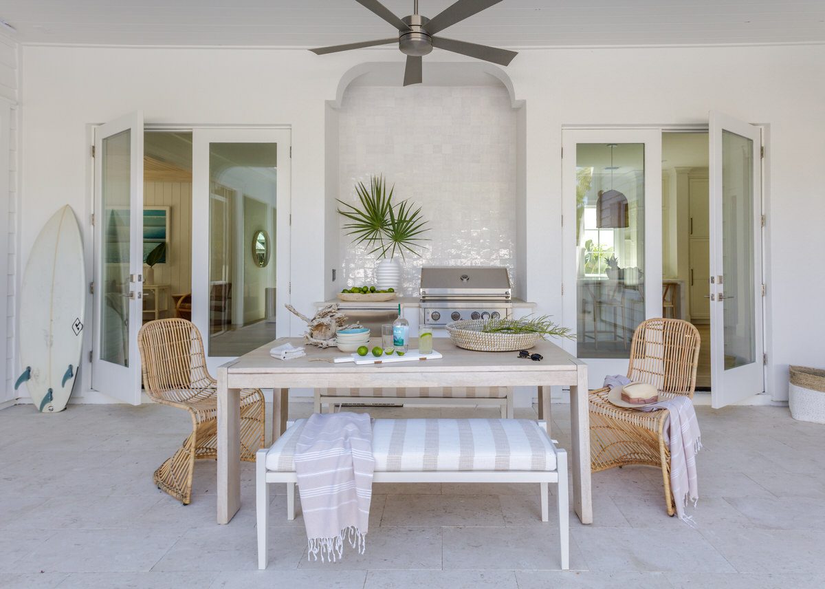 Covered porch with outdoor dining table, French doors, and built-in grill from a home addition by Alesch near Jacksonville Beach
