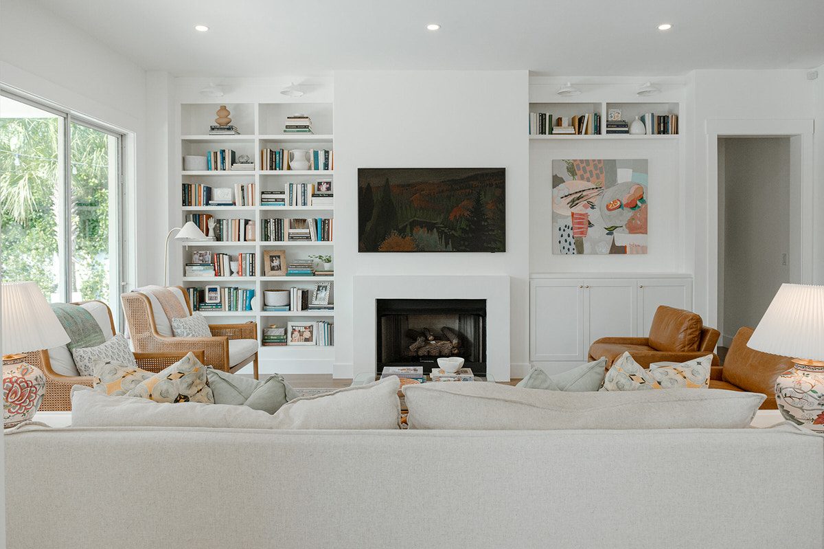Living room in a custom home by Alesch with built-in bookshelves flanking a fireplace and natural light from the yard