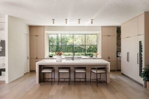 Light white oak kitchen with waterfall island and picture window, designed and built by Alesch, a design build firm serving Jacksonville