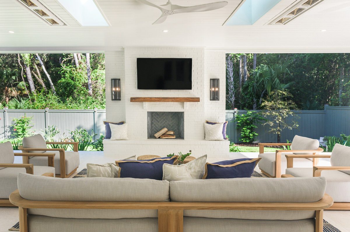 Outdoor living room addition with brick fireplace, mounted television, and skylit ceiling by Alesch, home addition contractor serving Jacksonville Beach